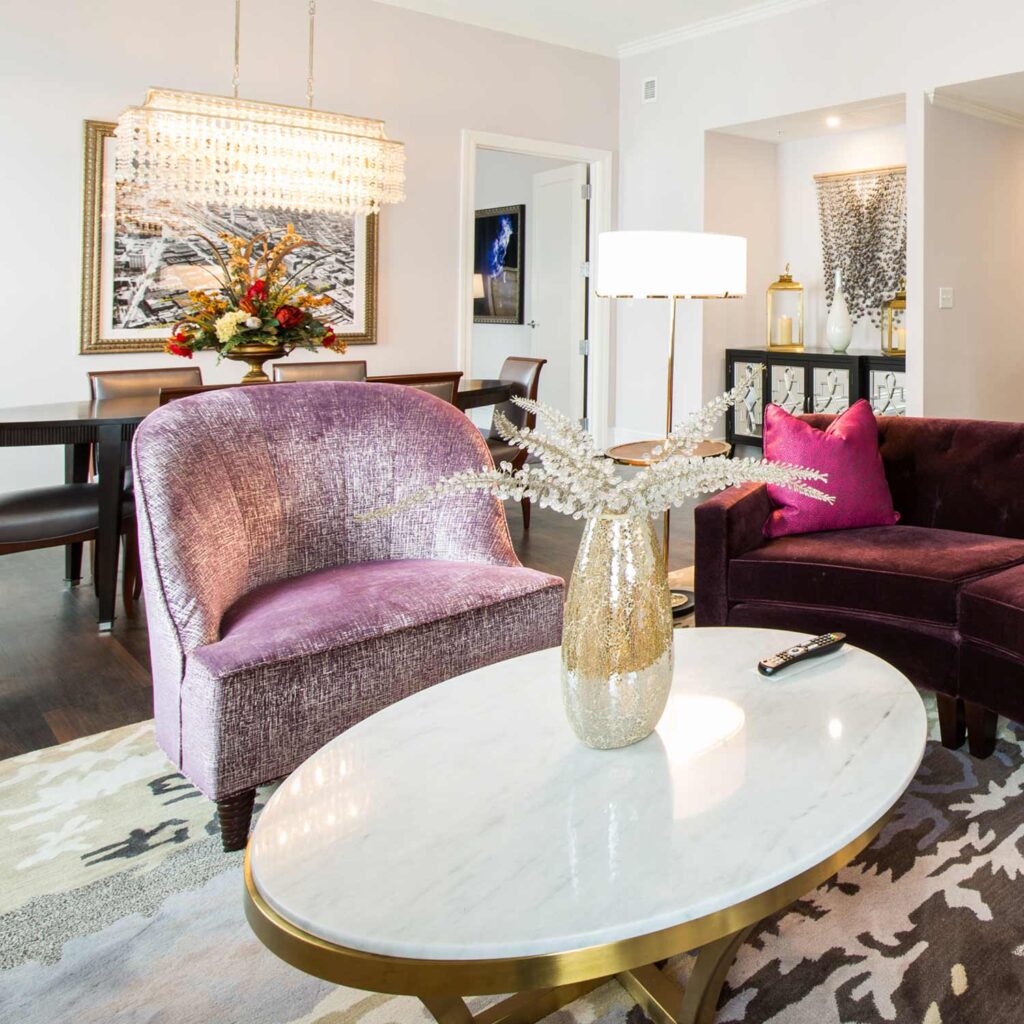 white marble table with purple suede couches next to it in a hotel suite