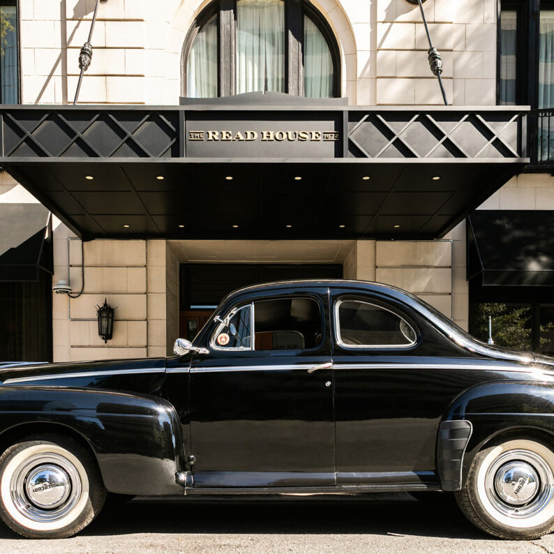 Car parked infront of the red house entrance