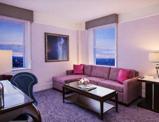 a living room filled with furniture and a painting on the wall