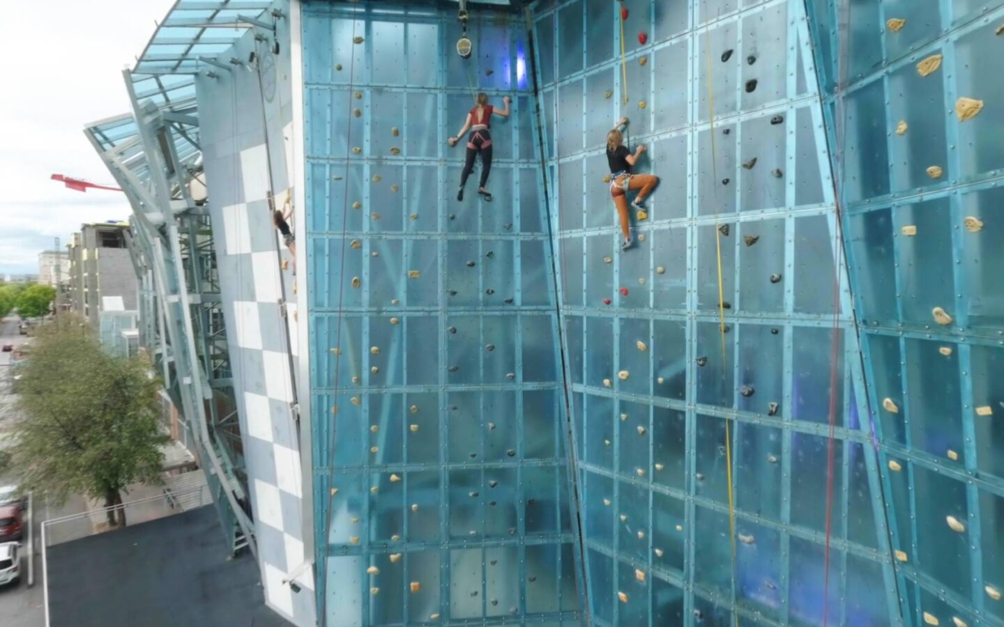 two people scaling a climbing wall