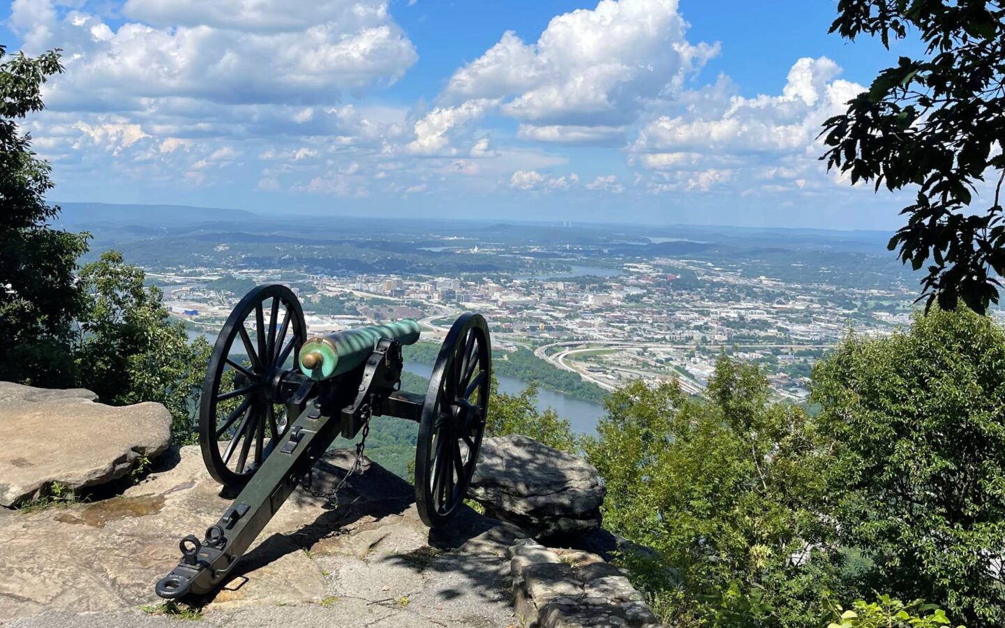 a civil war era cannon on a mountain overlooking a city