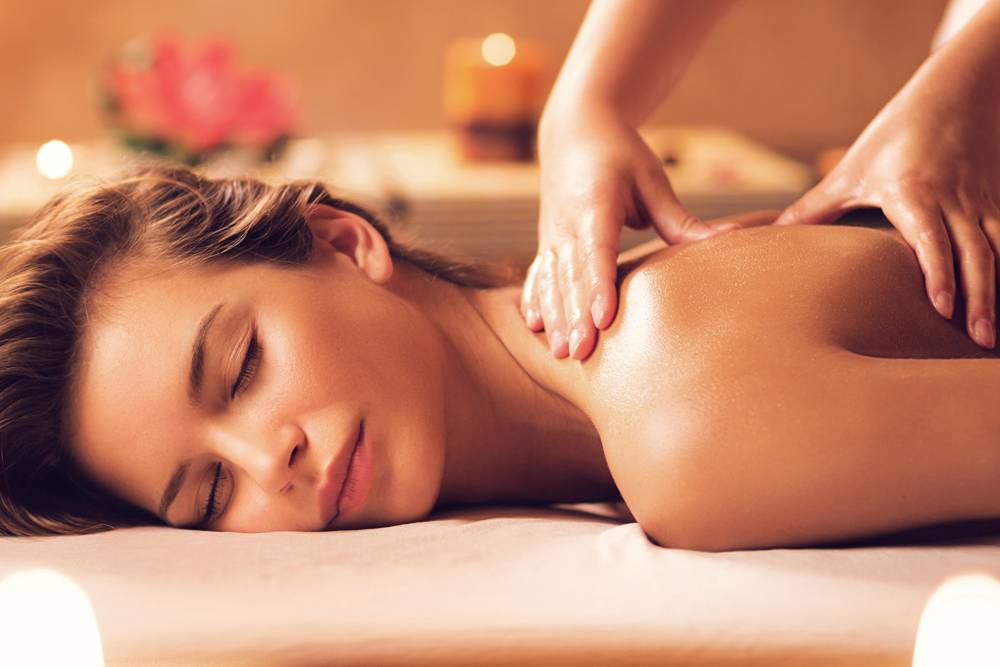 a woman lying on a massage bed receiving a massage